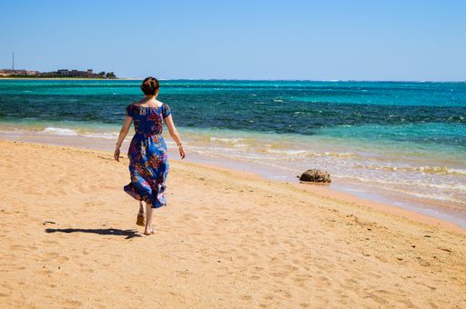 A closeup shot of a female walking on the beach on a sunny day