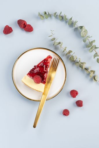 A vertical top view of a raspberry cheesecake on a white background