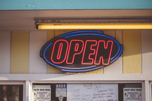 A closeup focus shot of an 'open' sign hanging on an ice cream store