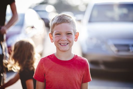 A closeup focus shot portrait of a cheerful young boy outdoors