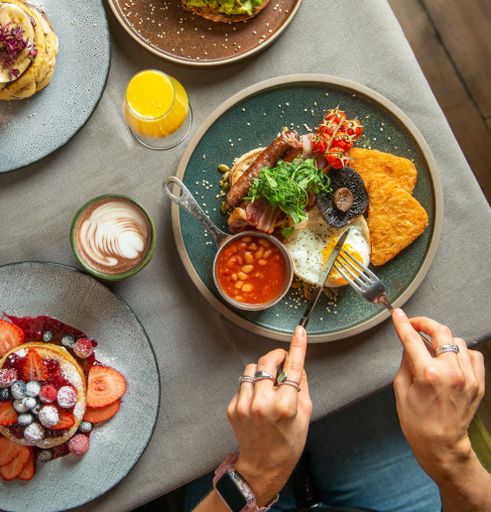 A vertical closeup of the table with various dishes. Traditional English Breakfast.