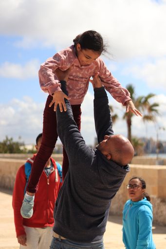 A vertical of African father and daughter playing with each other on the summer vacation