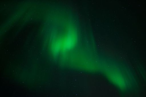 A beautiful shot of bright green aurora northern lights over mountains in Norway