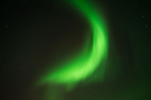 A beautiful shot of bright green aurora northern lights over mountains in Norway