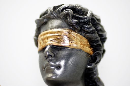 A closeup shot of the lady justice statue on a white background
