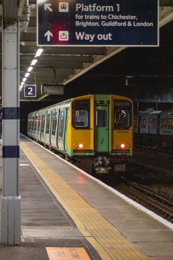 A vertical shot of the arriving train and the empty platform of the station.