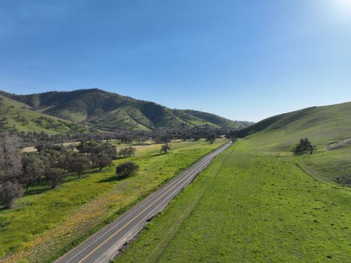 A long and straight road going towards the hill