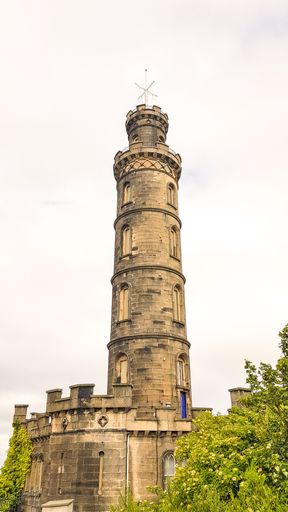 A vertical shot of the tower of the Nelson Monument in Edinburgh under the gloomy clouds