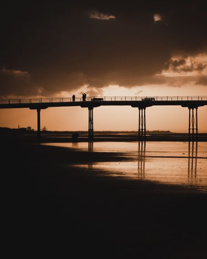 A silhouette shot of people at the pier at Saltburn beach in Saltburn-by-the-Sea, North Yorkshire