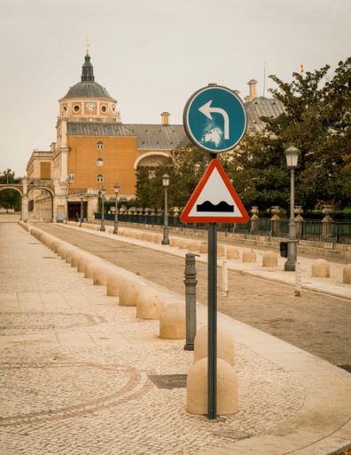 A closeup of road sign in background of palace Aranjuez in Spain