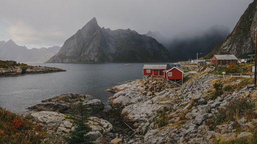 A scenic shot of houses and rock mountains surrounding the sea in Lofoten, Nordland, Norway
