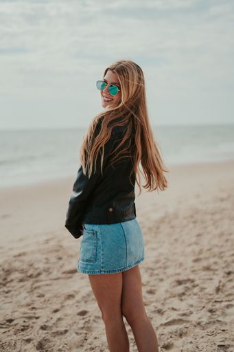The beautiful blonde woman smiling and posing in the beach