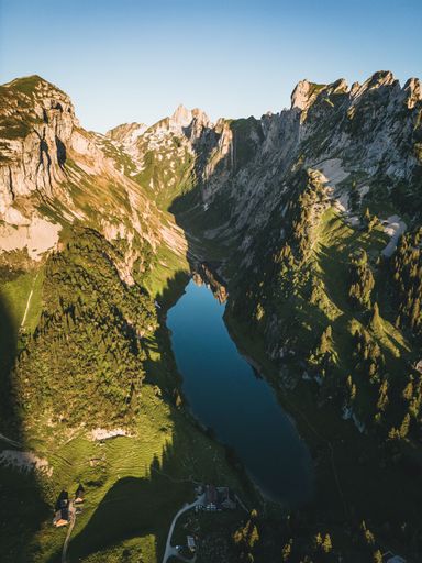 A vertical shot of a beautiful mountains landscape with a small lake in the middle