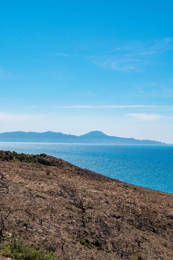 A beautiful seascape under a blue sky captured from a rocky cliff on the coast of Korbous, Tunisia