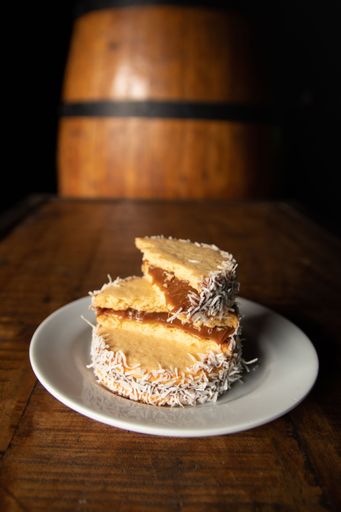A vertical shot of an Alfajores dessert on a white plate on a wooden table