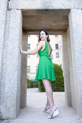 A vertical shot of the young woman with a green dress looking at camera