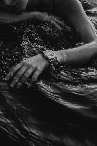 A grayscale shot of a girl in water