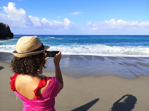 A woman taking photo of the sea in the beach