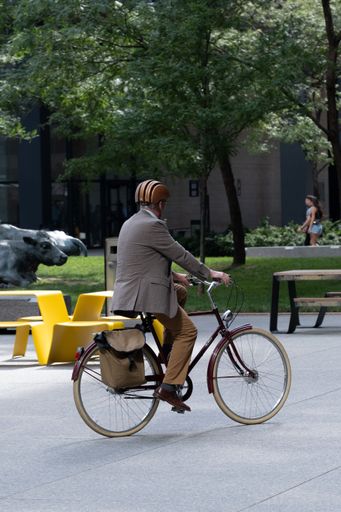 A vertical shot of a man riding an old-fashioned bike through TD Tower Plaza in Downtown Toronto, Canada