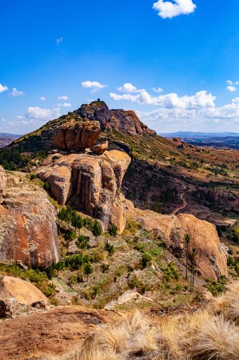 A scenic shot of boulders on top of a mountain overlooking farm fields in Antananarivo, Madagascar