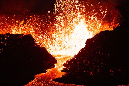 A beautiful shot of lava splashing from a volcano at night in Iceland