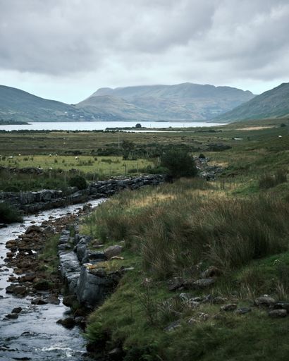 A vertical shot of Connemara Lake surrounded by mountains in Ireland on a gloomy day