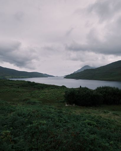 A vertical shot of Connemara Lake surrounded by mountains in Ireland on a gloomy day
