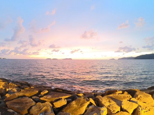 A rocky cliff near the ocean during sunset