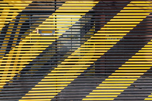 Wide stripes. Painted metal garage gate with yellow and black bands.
