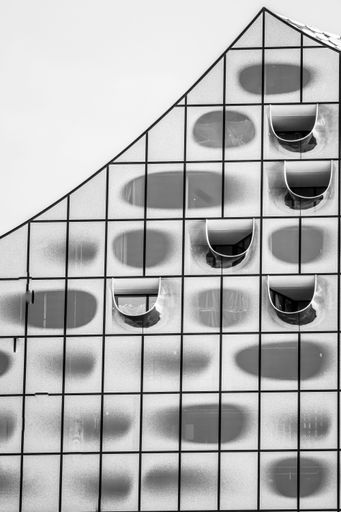 A vertical grayscale shot of the glass Elbphilharmonie building exterior in Hamburg, Germany