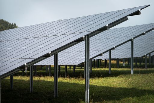 The solar system panels in the large photovoltaic power plant in the green field