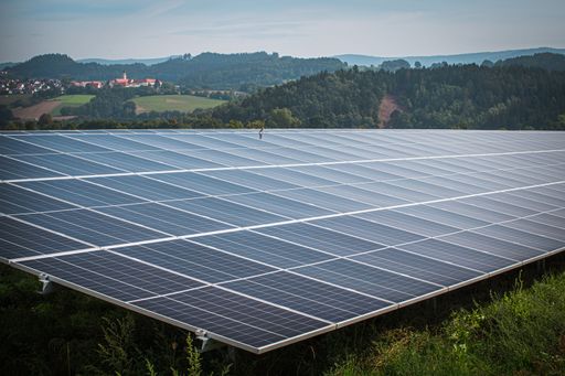 The solar system panels in the large photovoltaic power plant in the green field