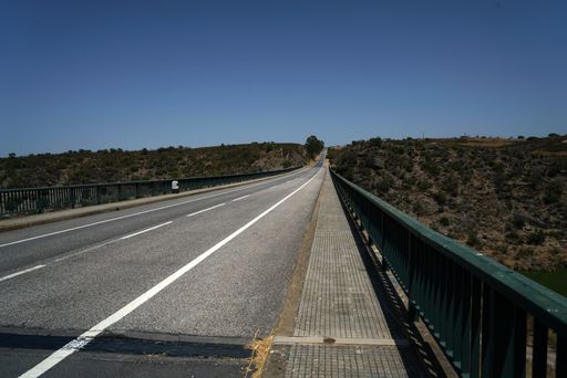 An empty street with metal borders during the daytime