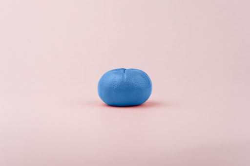 A manipulated shot of a blue tangerine on a pink background