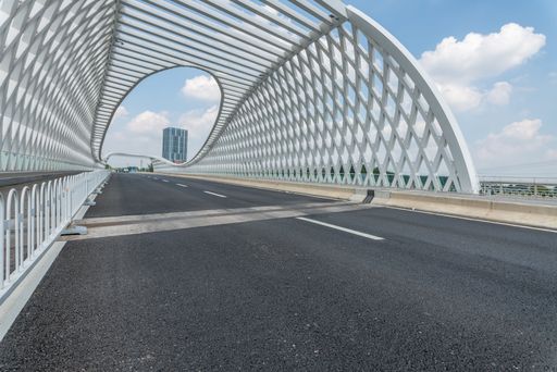 An Empty asphalt road on a bridge in downtown with cloudy sky