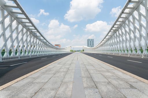 An Empty asphalt road on a bridge in downtown with cloudy sky
