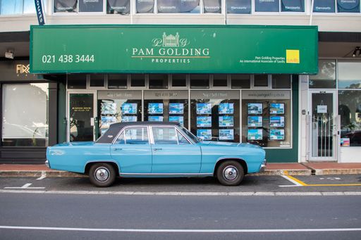 A vintage car parked in front of the Pam Golding Properties office in Camps Bay, Cape Town, South Africa