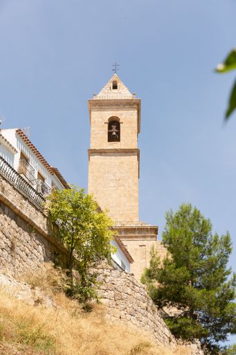 A low angle shot of a castle located on top of the hill in Alcala del Jucar against a cloudless sky