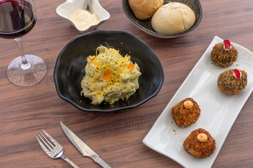 A top view of shrimp and crab risotto and variety of delicious dishes on a wooden restaurant table