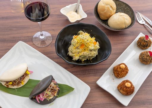 A top view of shrimp and crab risotto and variety of delicious dishes on a wooden restaurant table