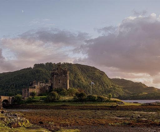 A beautiful shot of a historic ruin surrounded by hills and nature during sunset
