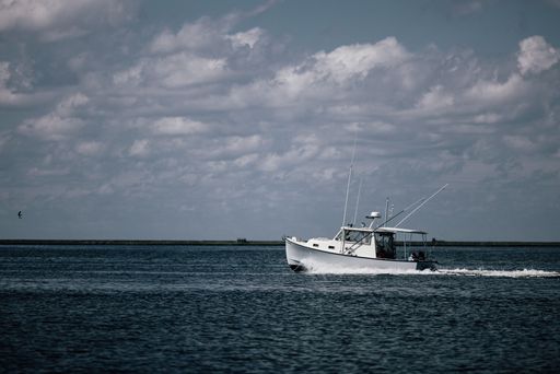 A closeup shot of a sailboat on the ocean on a cloudy day