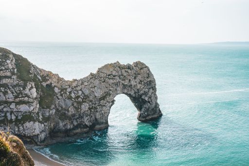 a high angle shot of Durdle Door limestone arch on the Jurassic Coast near Lulworth in Dorset, England