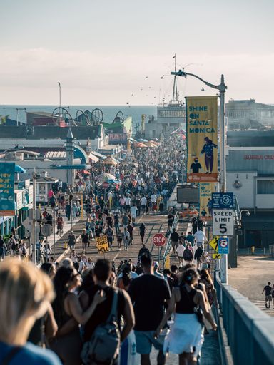 A vertical shot of people on a pier around sunset in Los Angeles, California, United States