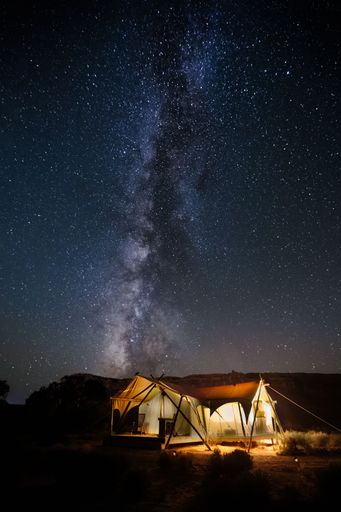 A vertical of a camping under a beautiful starry sky.