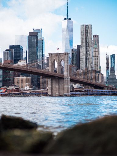 A vertical shot of the Brooklyn bridge and modern buildings in Manhattan. New York, USA