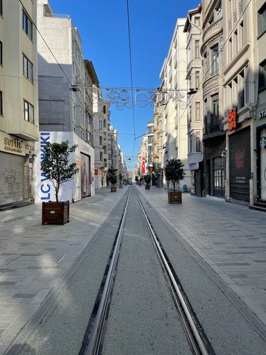 A beautiful view of an empty street with tram rails and shops