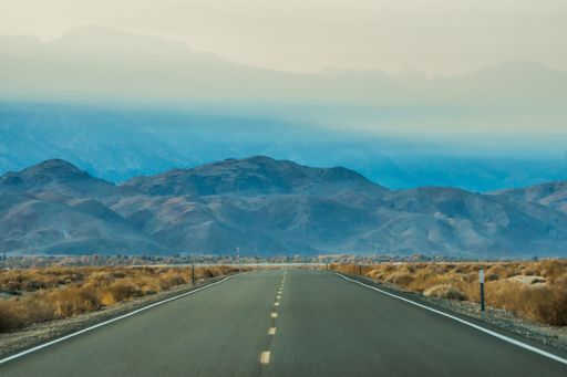 A black and white shot of an empty road leading to the death valley national park