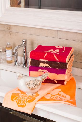 A vertical shot of folded colorful bamboo towels on a decorative bathroom cabinet