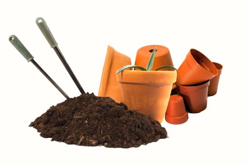 The gardening tools with a bunch of soil and plant pots isolated on an empty white background